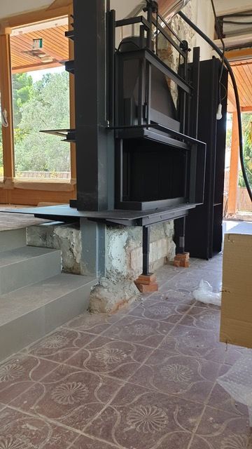 Se está construyendo una chimenea en una habitación con suelo de baldosas.