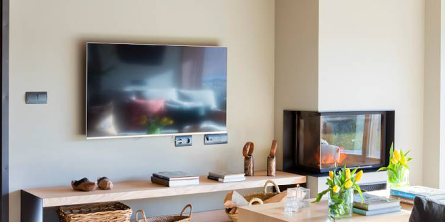 Una sala de estar con chimenea y un televisor de pantalla plana en la pared.