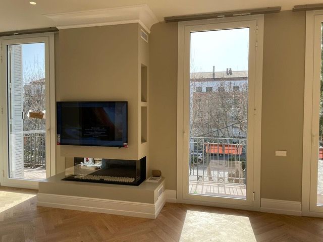 Una sala de estar con chimenea y un televisor de pantalla plana en la pared.