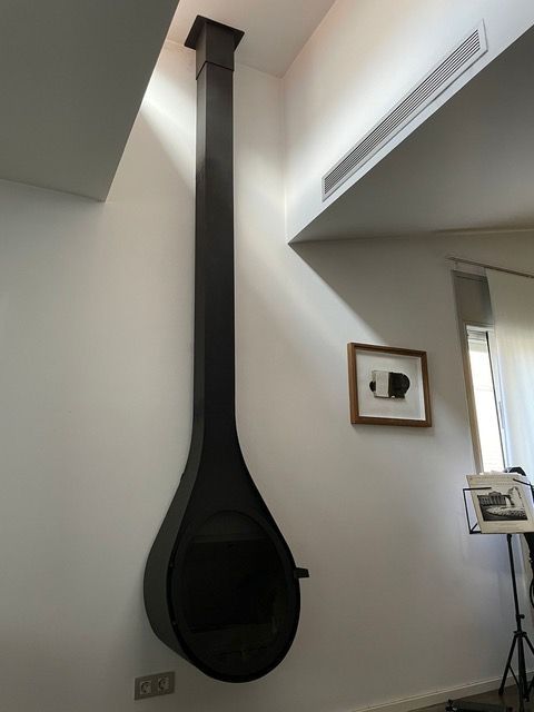 Una chimenea cuelga del techo en una sala de estar.