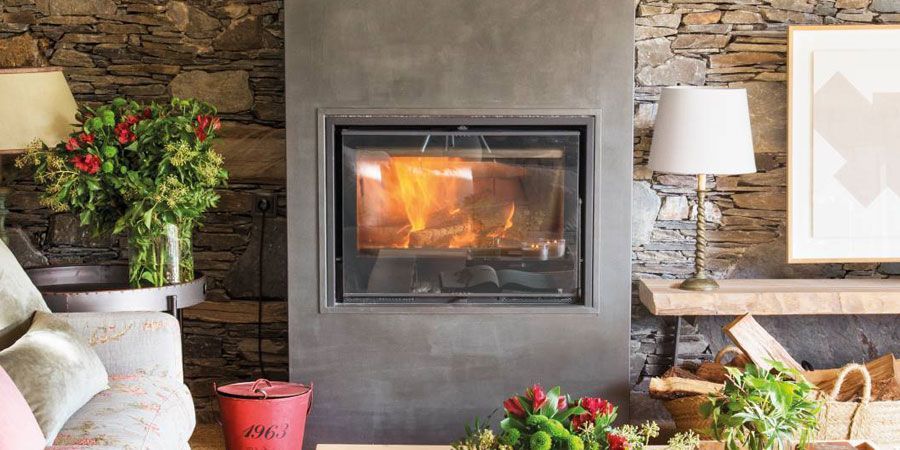 Una sala de estar con chimenea y una pared de piedra.