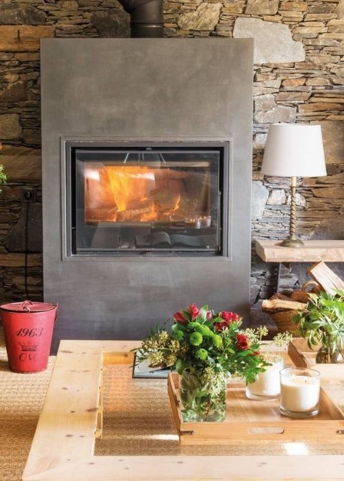 Una sala de estar con chimenea y una mesa con flores y velas.