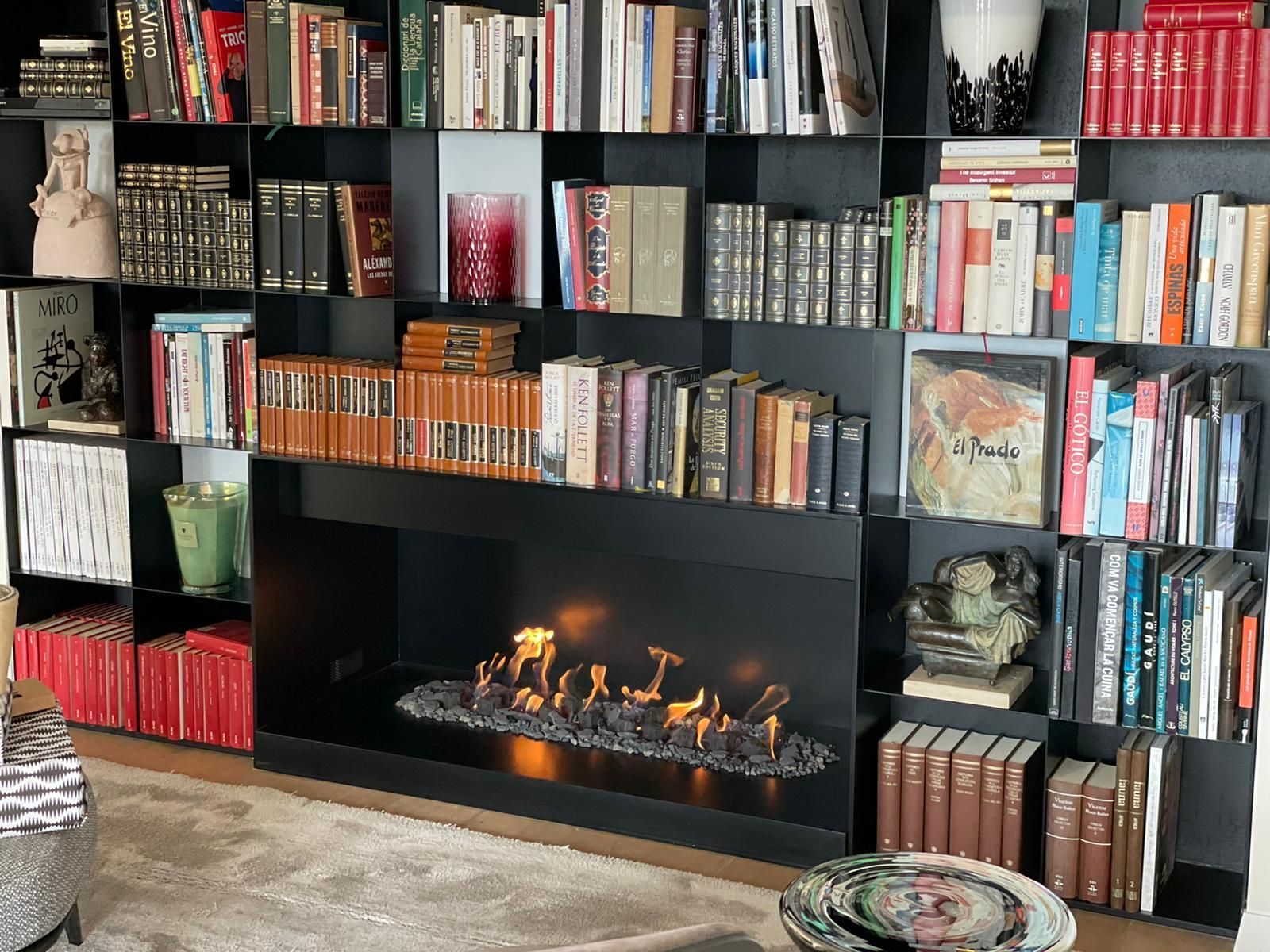 Una sala de estar llena de libros y una chimenea.