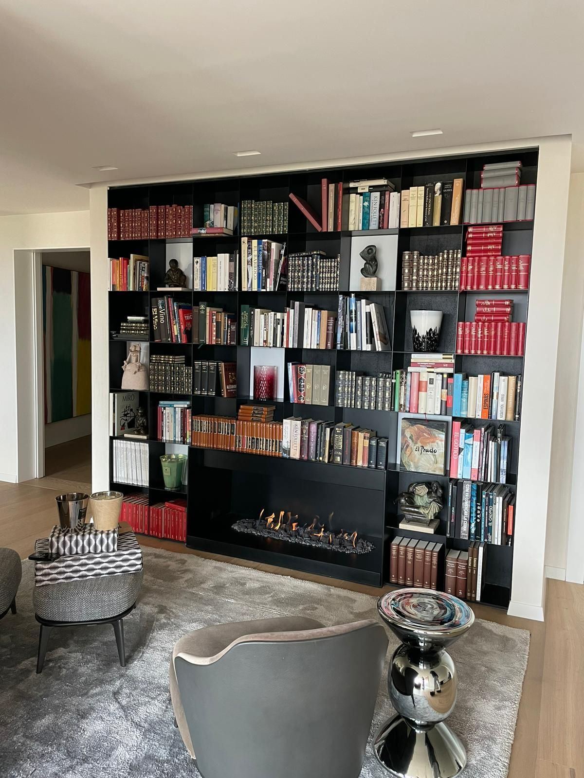 Una sala de estar con chimenea y muchos libros en las estanterías.