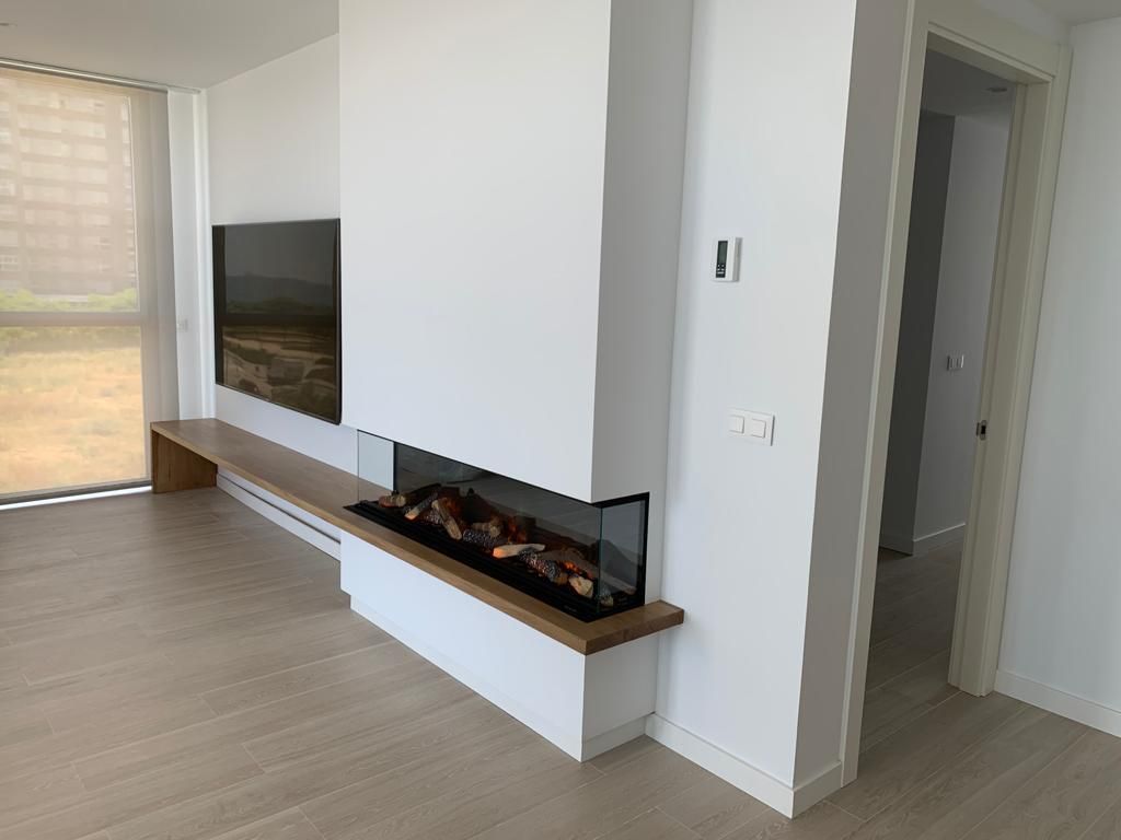 Una sala de estar con chimenea y TV de pantalla plana.