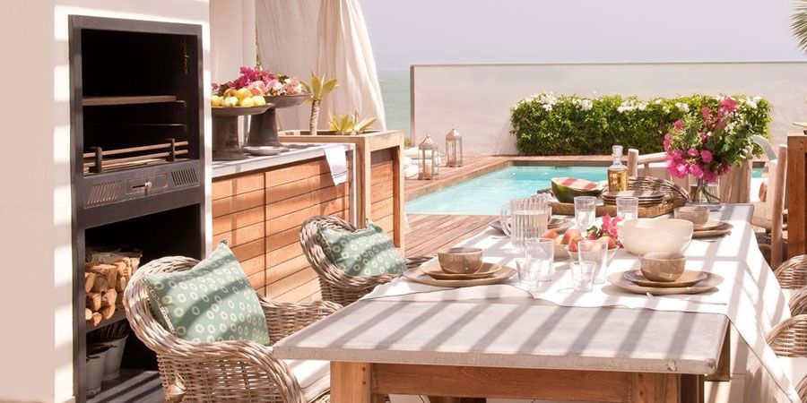 Hay una mesa y sillas frente a una piscina.