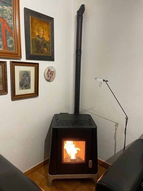 Una habitación con chimenea y cuadros en la pared.