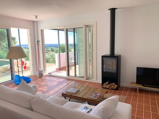 Una sala de estar con sofá, mesa, televisión y chimenea.