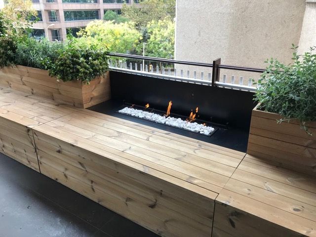 Un banco de madera con un pozo de fuego en el medio.