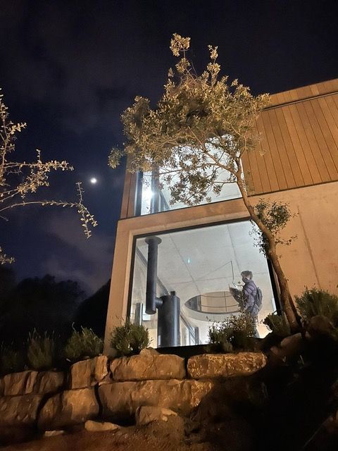 Una casa con un árbol delante de ella por la noche.