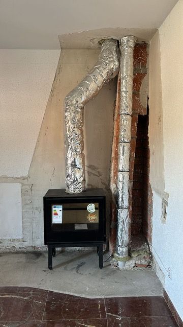 Una chimenea con dos tubos que salen de ella en una habitación.