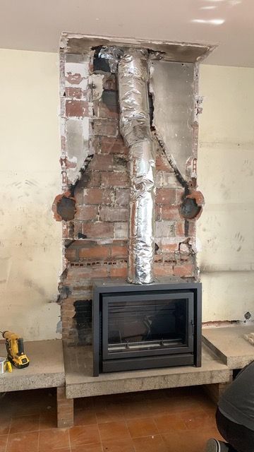 Se está remodelando una chimenea de ladrillo en una sala de estar.