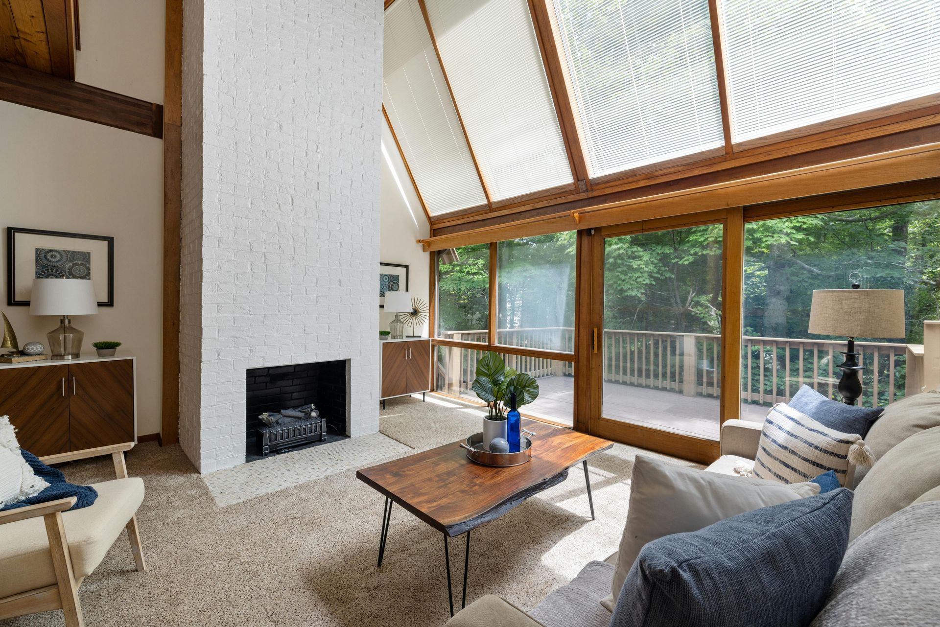 A living room with a fireplace and lots of windows