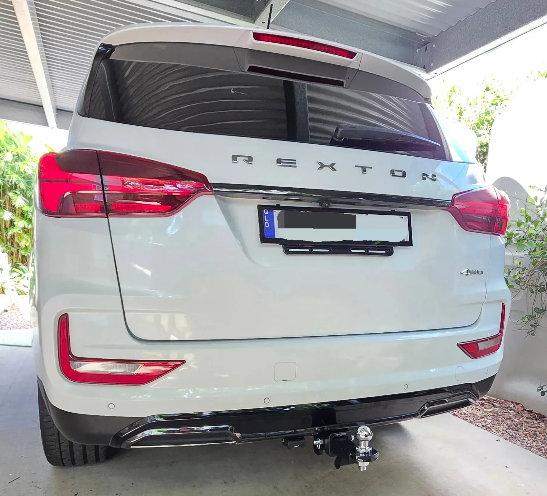 White Proton X70 SUV Parked Under A Carport, Rear View With License Plate Obscured — Hinterland Towbars in North Sunshine Coast, QLD