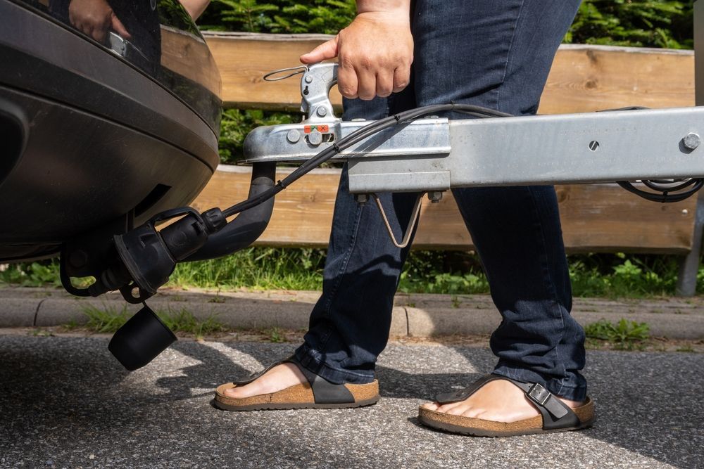 Person Connecting Trailer to a Car — Hinterland Towbar & Steel Fabrication In Tin Can Bay, QLD