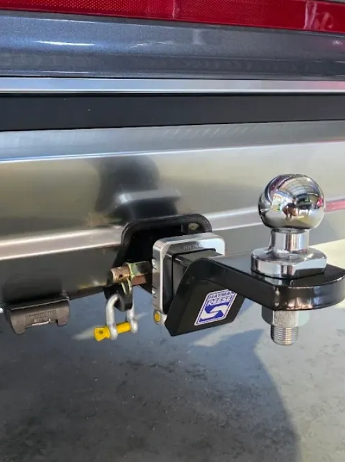 Close-up Of A Trailer Hitch With A Shiny Chrome Ball Mount And Black Hitch Cover On A Silver Vehicle — Hinterland Towbars in Tin Can Bay, QLD