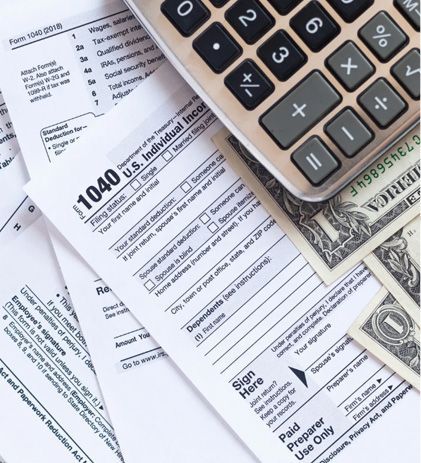 Tax forms, calculator, and cash for tax preparation.