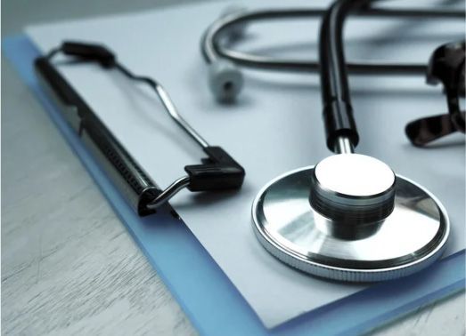 Stethoscope on clipboard, medical instruments on white paper.