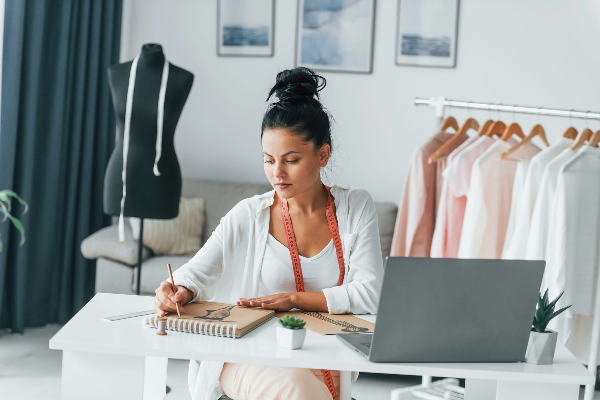 Woman in white shirt sits on a sofa, hands clasped. Reflection visible on a table.