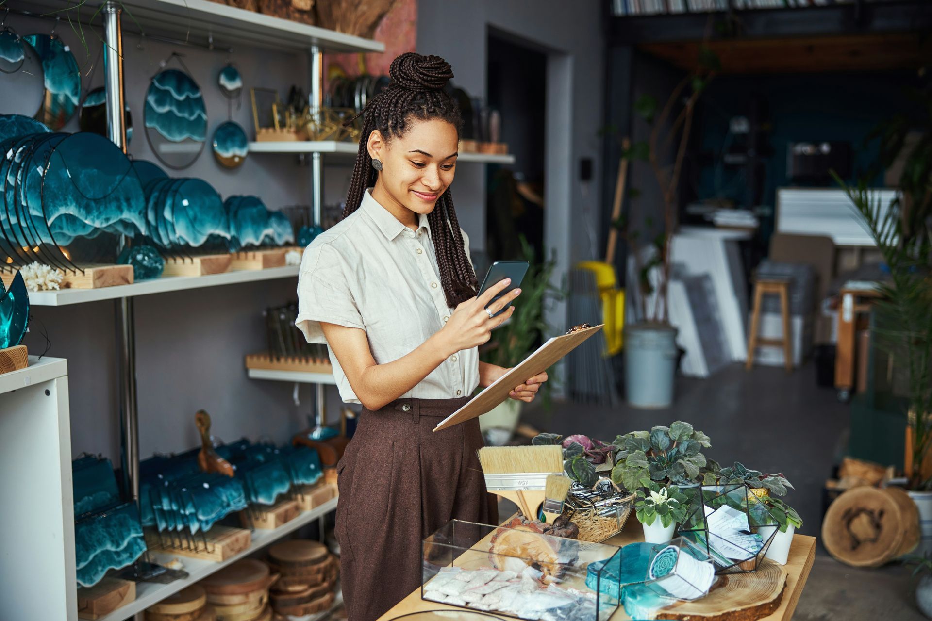 Woman in white shirt sits on a sofa, hands clasped. Reflection visible on a table.