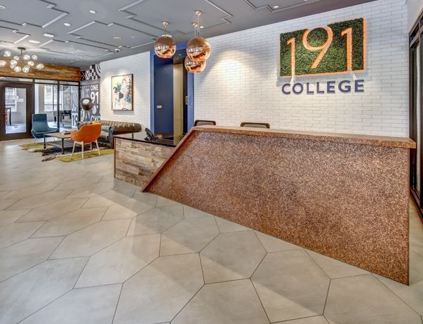 A lobby with a reception desk and a sign that says 191 college