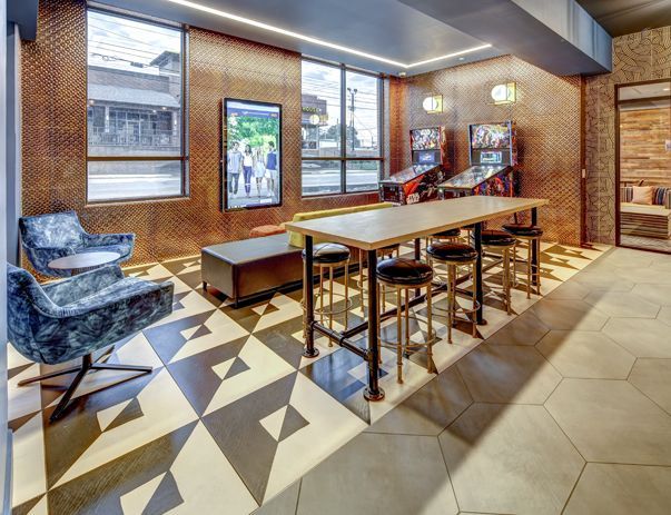 A room with a table , chairs , and arcade games.