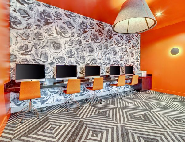 A room with a lot of computers and chairs in it