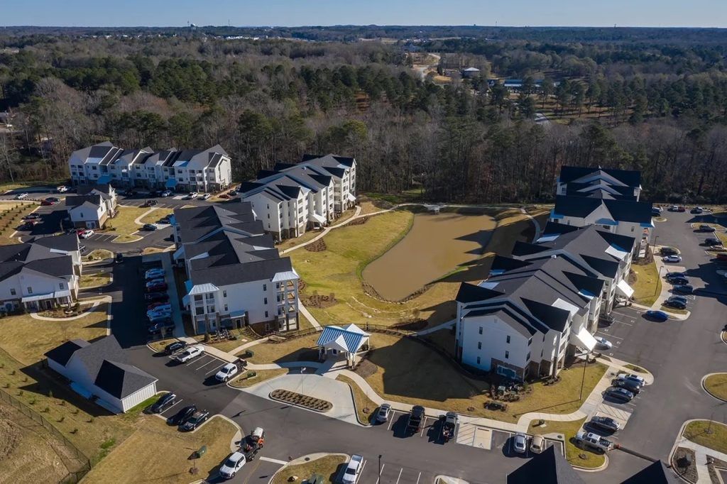 An aerial view of a residential area with houses and a parking lot.