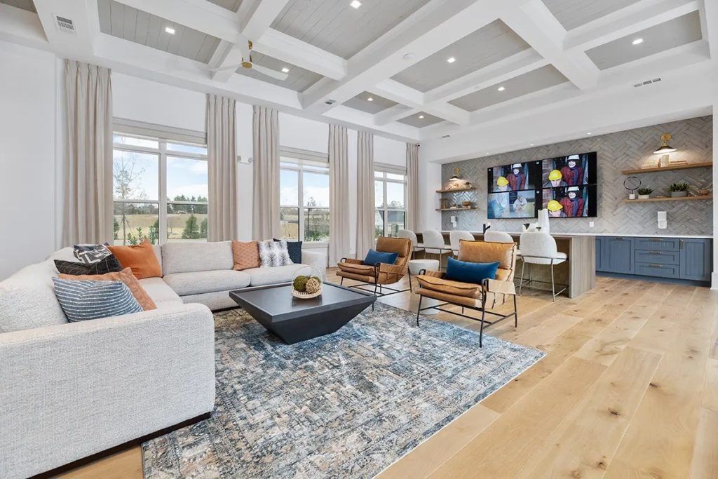A living room with a couch , chairs , coffee table and rug.