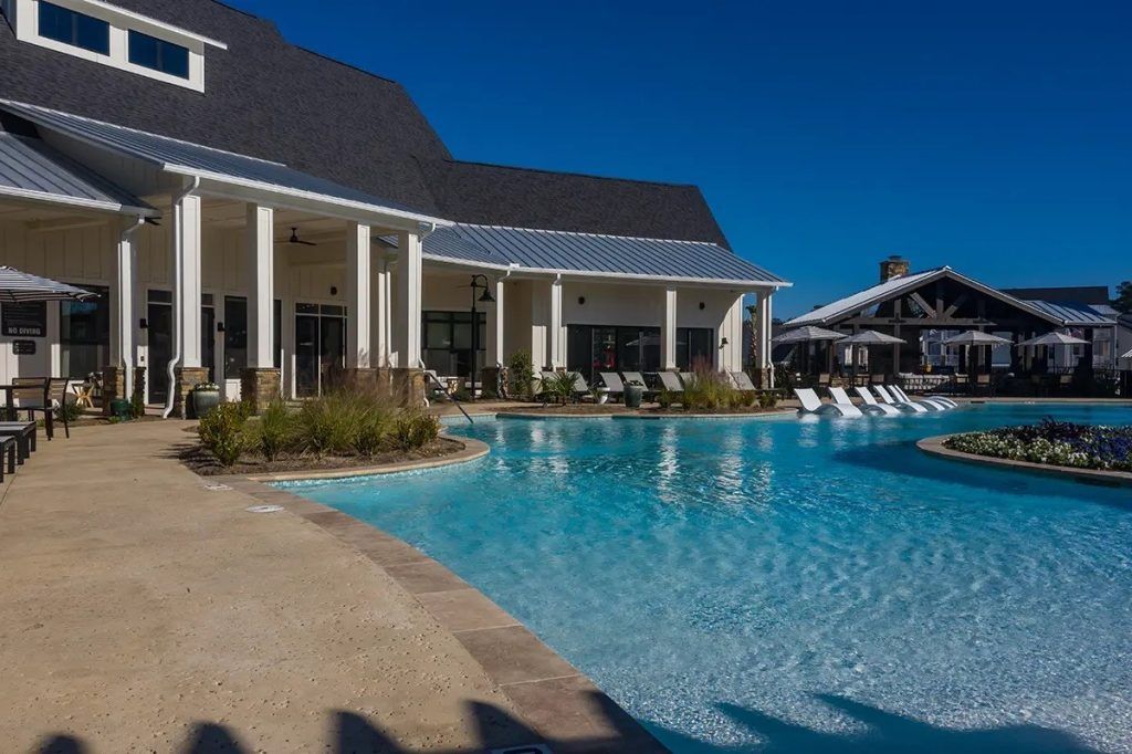 There is a large swimming pool in front of a building.