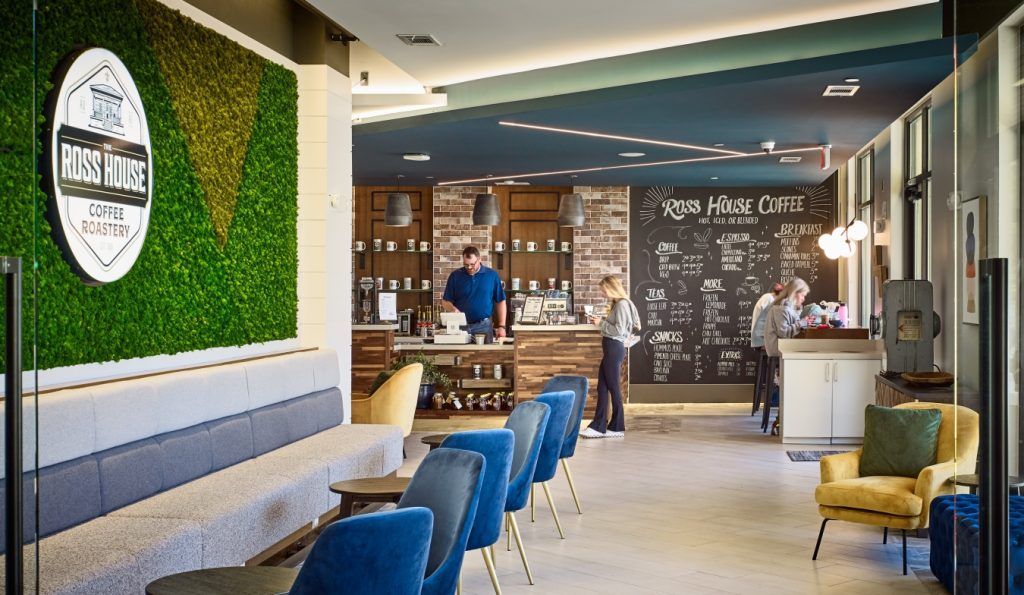 A man is standing at a counter in a restaurant.