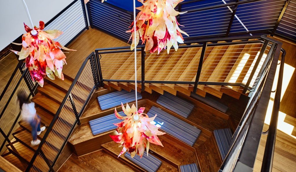 A woman is walking down a set of stairs in a building