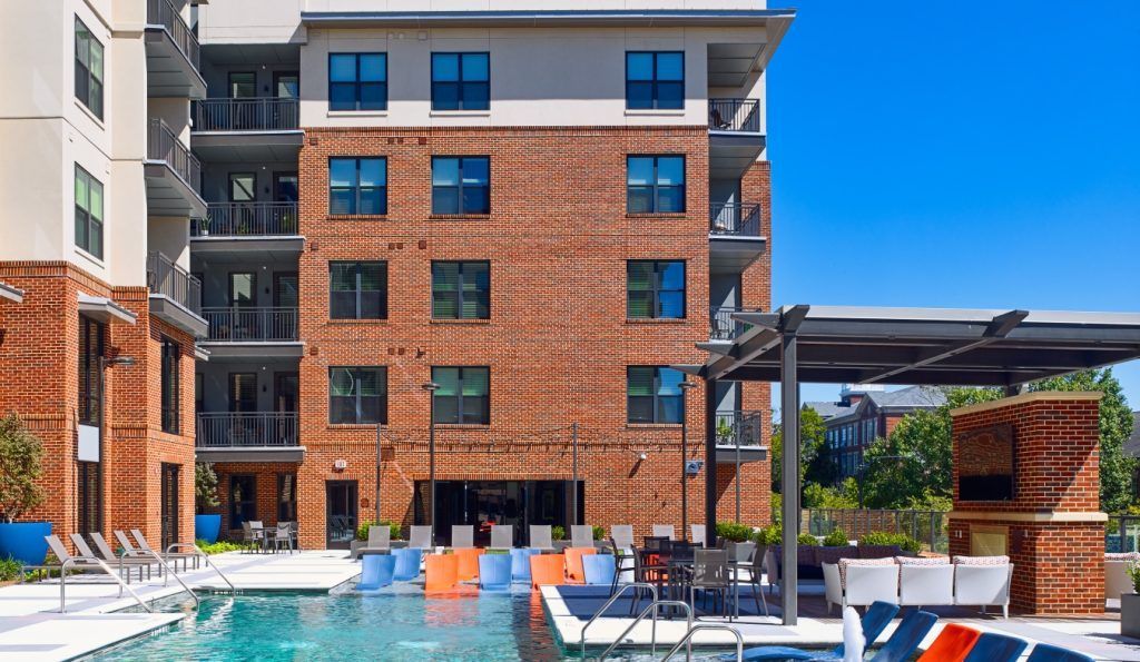 A large brick building with a swimming pool in front of it.