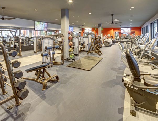 A large gym filled with lots of exercise equipment.