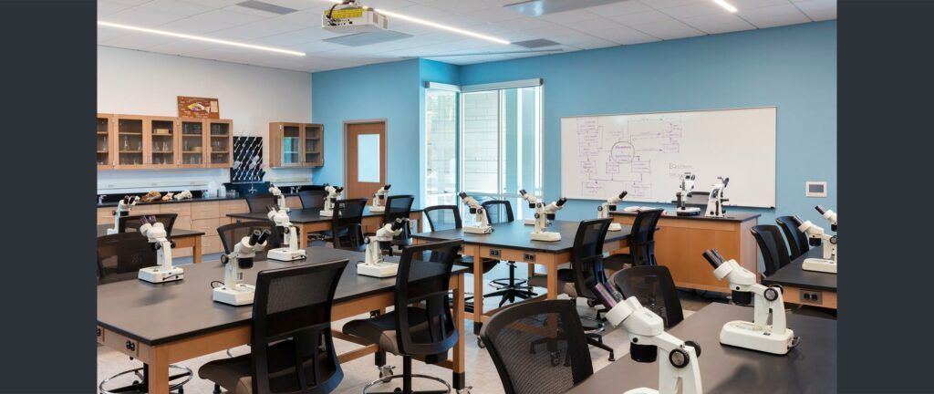 A classroom filled with tables and chairs and microscopes.