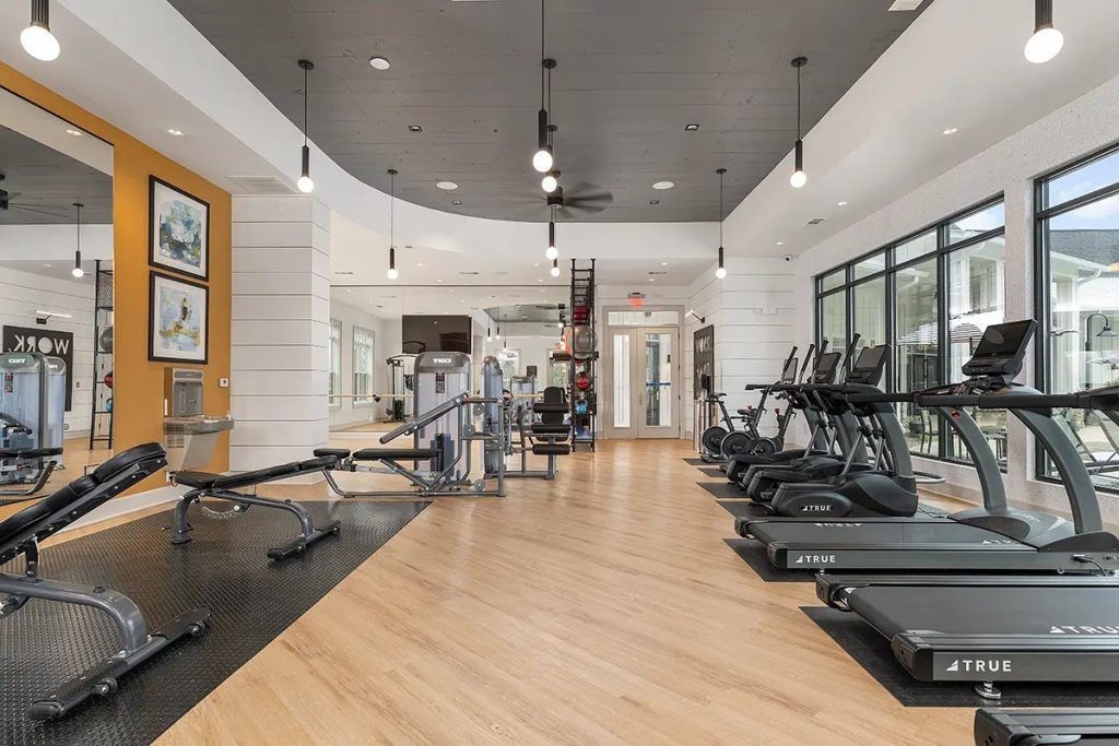 A large gym with a lot of treadmills and exercise equipment.