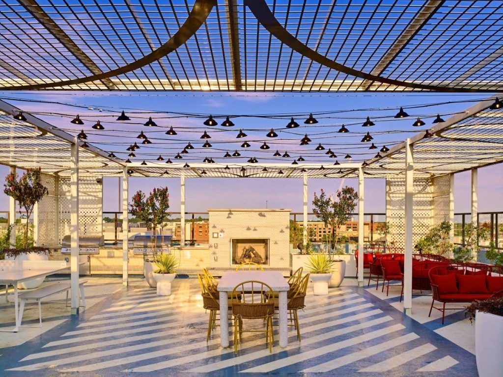 An artist 's impression of a rooftop patio with tables and chairs and a fireplace.