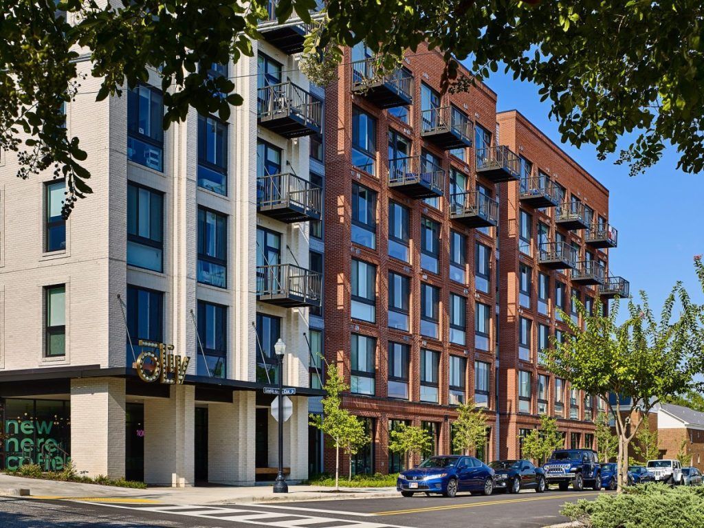 A large apartment building with cars parked in front of it