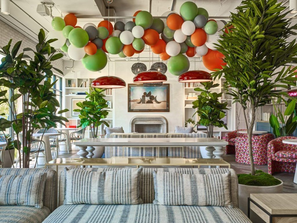 A living room with a couch and balloons hanging from the ceiling.
