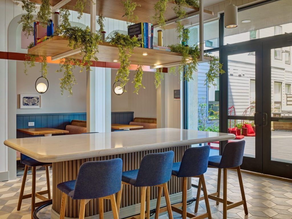 A restaurant with a long table and blue chairs.