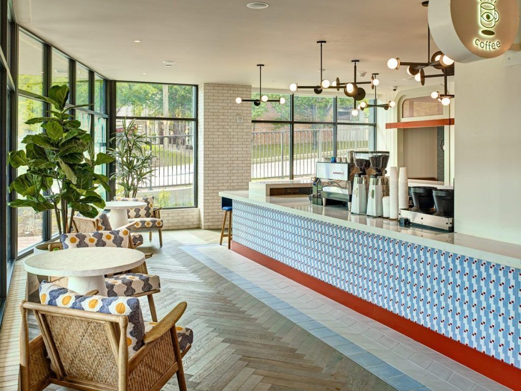 A restaurant with tables and chairs and a long counter.