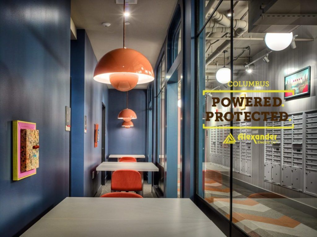 A hallway with tables and chairs and a sign that says `` powered protected ''.
