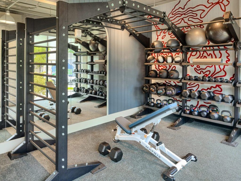 A gym with a lot of dumbbells and a bench.