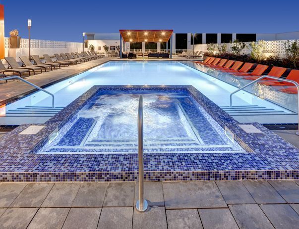 A large swimming pool with a jacuzzi in the middle of it