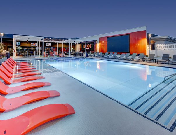 A large swimming pool with a large screen on the side of it