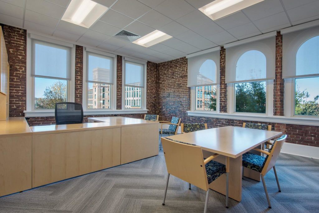 A large room with a table and chairs in it.