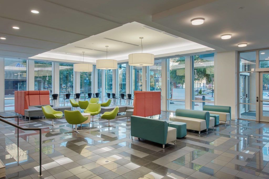 A large lobby with a lot of furniture and a lot of windows.