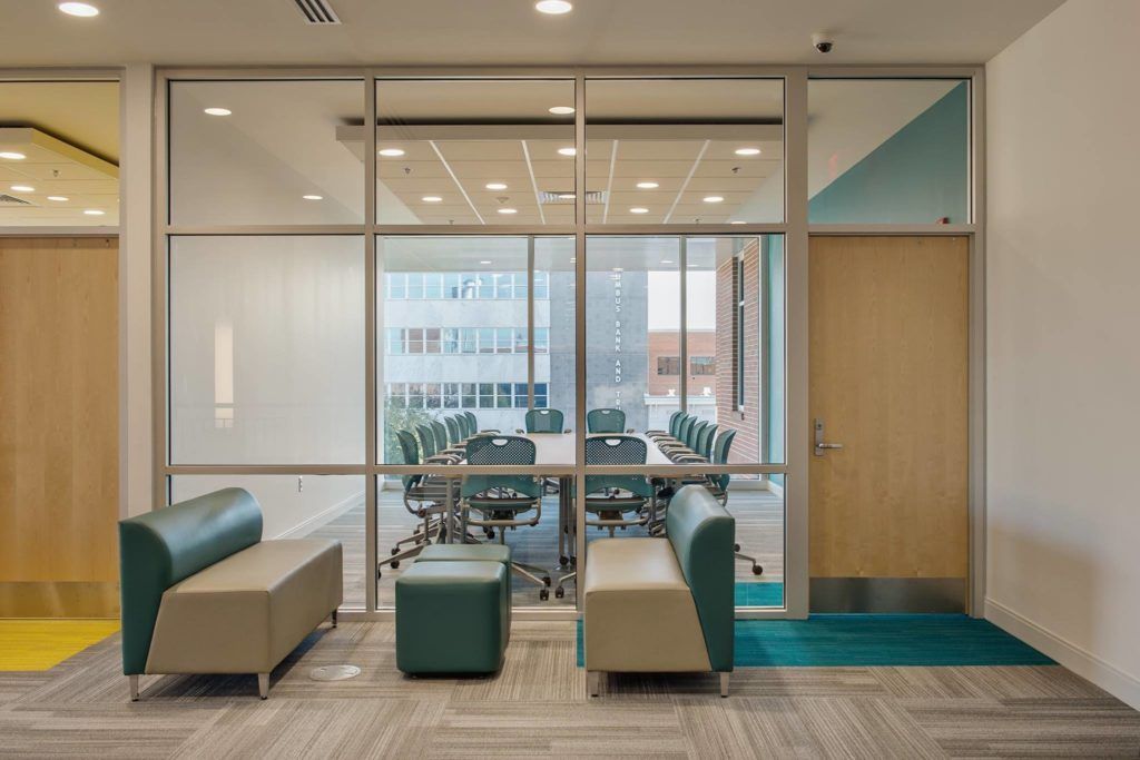 A room with a table and chairs in it and a glass wall.