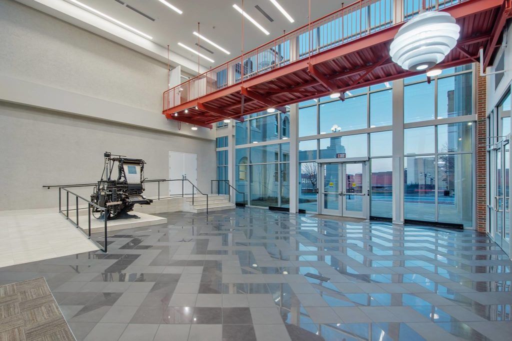 A large empty room with a lot of windows and a balcony.