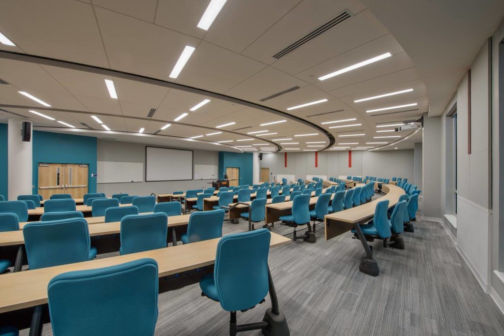 A large lecture hall filled with tables and chairs.